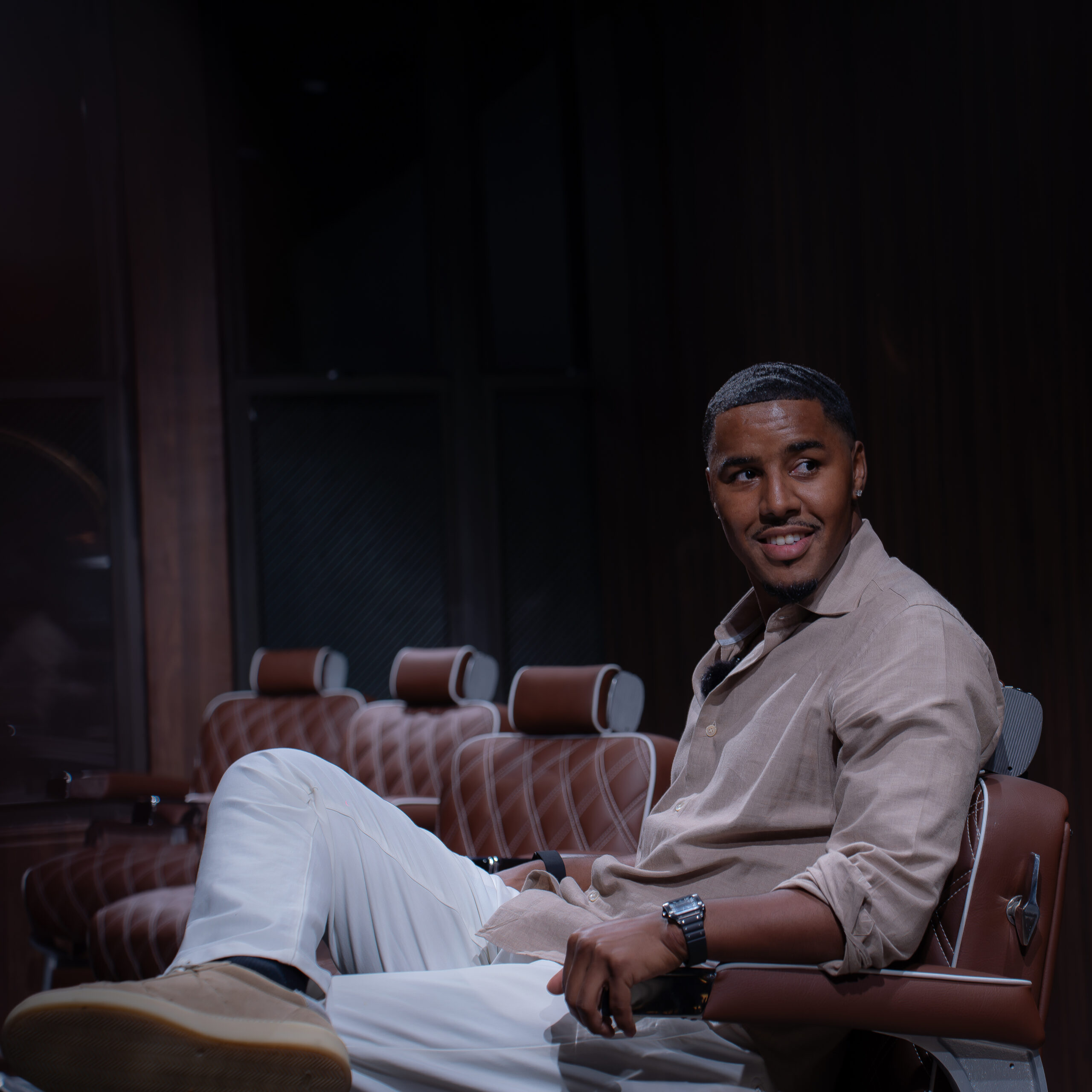 Client relaxing in a leather barber chair at The Upper Seat men's grooming club in the Garment District, NYC