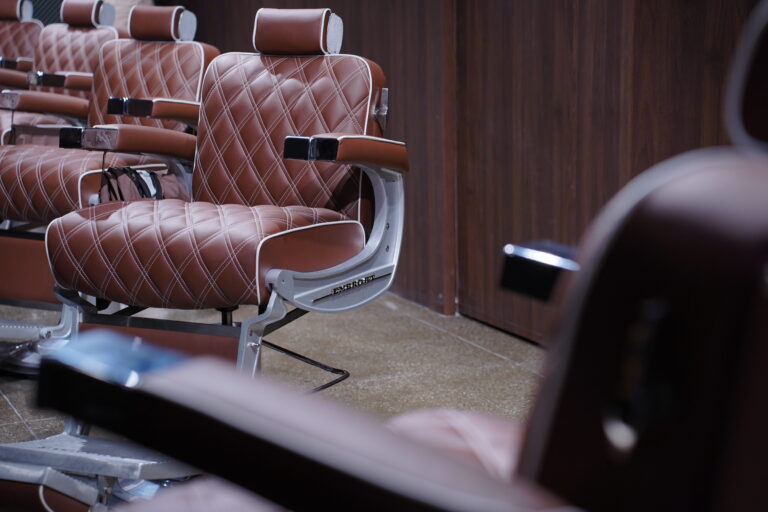 Row of quilted leather chairs at The Upper Seat men’s grooming club near Penn Station