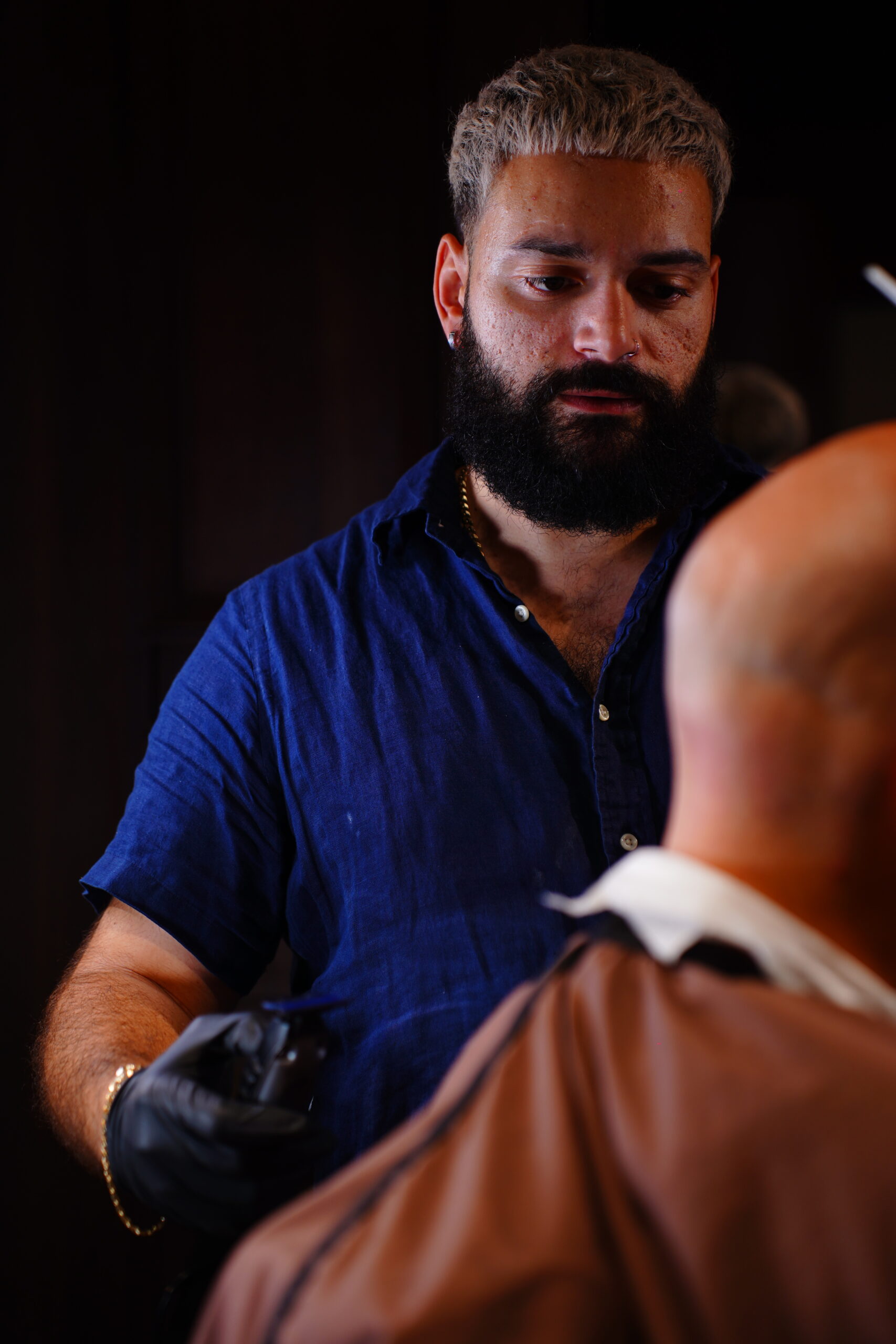 Barber Chec giving a precision haircut at The Upper Seat barbershop in the Garment District, NYC